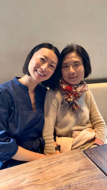 Picture of a mother and daughter at a restaurant smiling happily