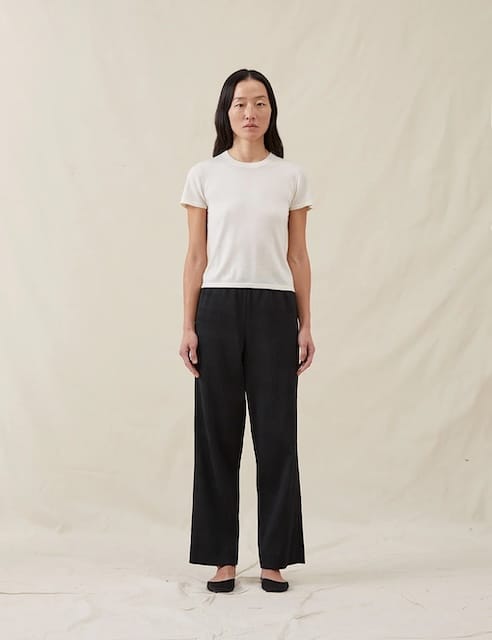 Picture of a woman wearing a ivory cashmere tee and black ribbed pants