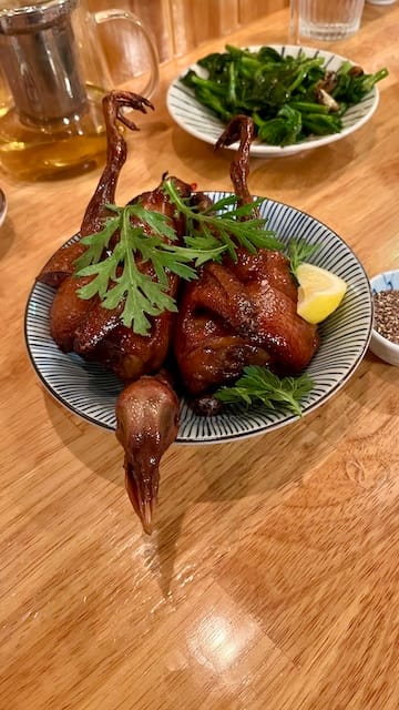 Picture of a fried quail in a bowl on a table