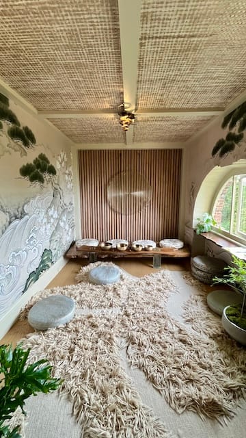 picture of a mediation room with a bamboo wall at the center and a shaggy rug