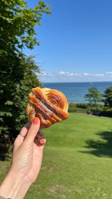 Photo of a woman's hand holding up a cardamom bun