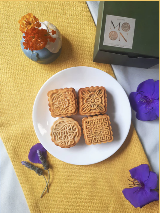 Picture of a plate of mooncakes on a yellow tablecloth