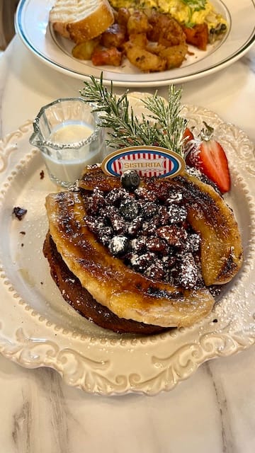 Picture of a plate of french toast with bananas, walnuts, and sugar
