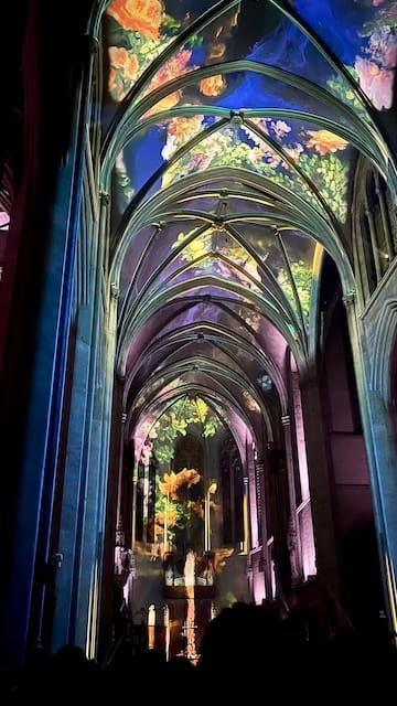 Picture of a cathedral interior with flowers projected on the walls
