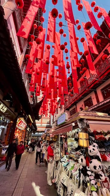 A picture of a bazaar with red lanterns hanging